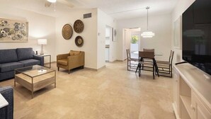 Un salon moderne comprenant un canapé, une table basse et un coin repas avec des chaises et une table.