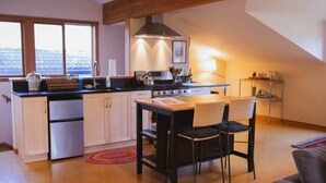 A compact kitchen with a dining area, a stove, and a sink.