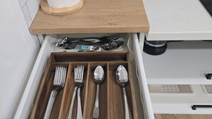 Eine Küche mit Holzauszug, einer Papiertuchhalterung und einer Schublade mit Besteck.