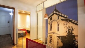 A modern interior with a staircase, a bed, and a large framed picture of a building. - Family Time Duplex Family Getaway with Pool (Providencia)