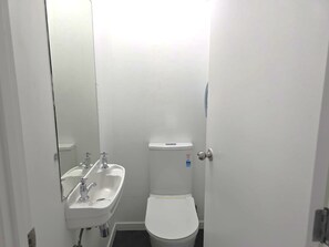 A small, white bathroom with a sink and toilet. - SpinCity Lodge Auckland (Auckland)