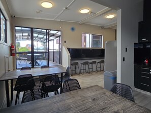 A modern kitchen with a dining area, large windows, and a fire extinguisher. - SpinCity Lodge Auckland (Auckland)