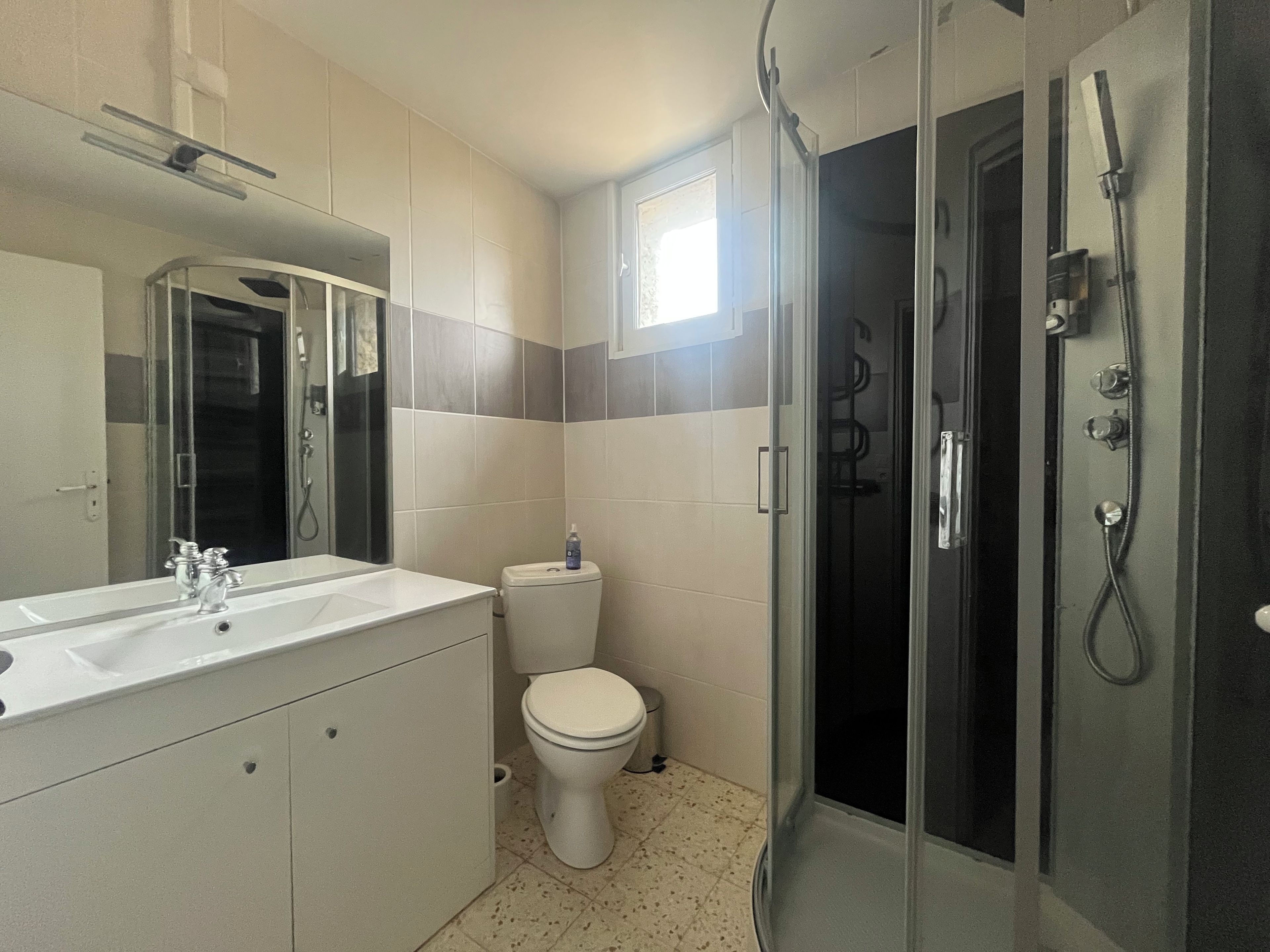 A bathroom with a shower, toilet, and sink.
