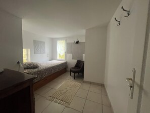 Une chambre à coucher avec un lit, une chaise, un tapis et une fenêtre.