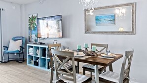 A dining area with a wooden table, chairs, and a chandelier. - Oceanfront 2BR Condo with Large Balcony & Beach Access! 🌴 (Satellite Beach)