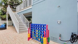 A residential outdoor area with a staircase, a colorful board game, and a hose. - New! Gorgeous home on AMI. Heated pool! (Anna Maria)