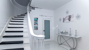A white staircase with black steps leading to a door with a blue door frame. - Beachfront Luxury in Cable Beach West - Sleeps 6+ (Nassau)