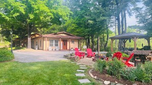 A lodge with a welcoming entrance, a covered outdoor seating area, and a well-maintained garden. - Private, secure and serene getaway at Oak Grove Cottage! (Arden)