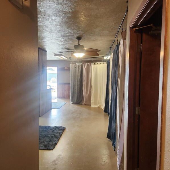 Un pasillo con ventilador de techo, cortinas y alfombra.