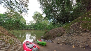 Un río tranquilo con kayaks y un sendero de piedra.