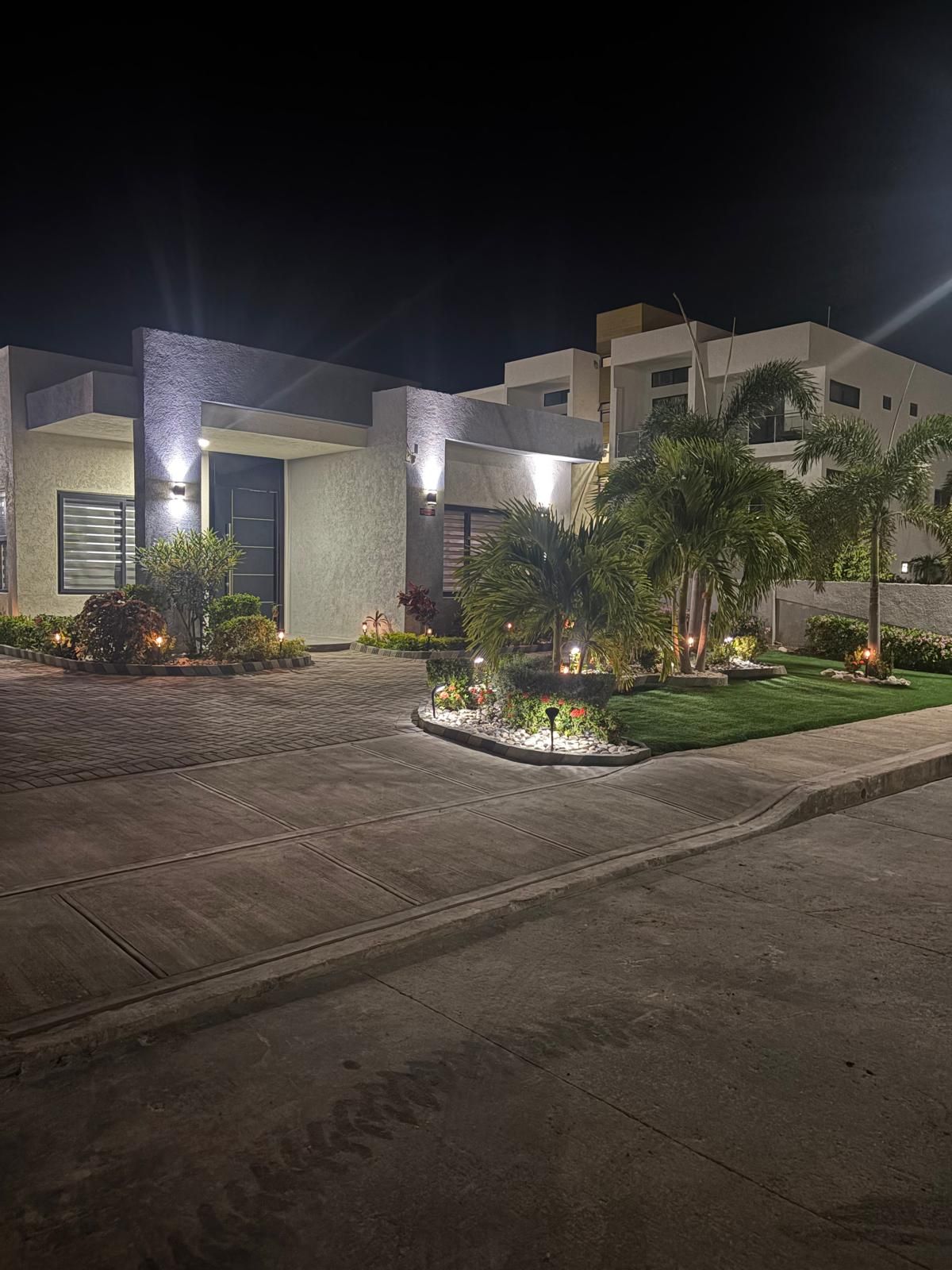 A modern building with a paved driveway and landscaped garden.