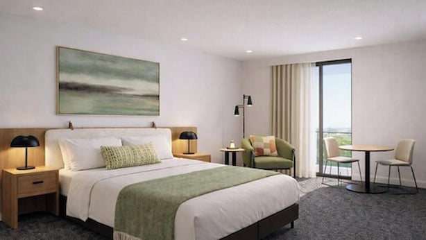 A hotel room with a bed, bedside tables, a desk, a chair, a round table, and a large window. - Quest Havelock North (Havelock North)