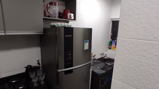 A kitchen with a stainless steel refrigerator, a stove, and a sink. - Comfortable, fully equipped 3-bedroom apartment with garage and 24-hour security. (Belém)