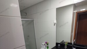 A compact bathroom with a toilet, sink, and shower. - Comfortable, fully equipped 3-bedroom apartment with garage and 24-hour security. (Belém)