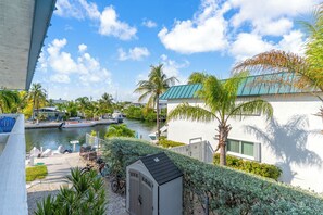 A residential area with a canal, boats, and a small shed. - Sombrero Beach Getaway - Pool (Marathon)