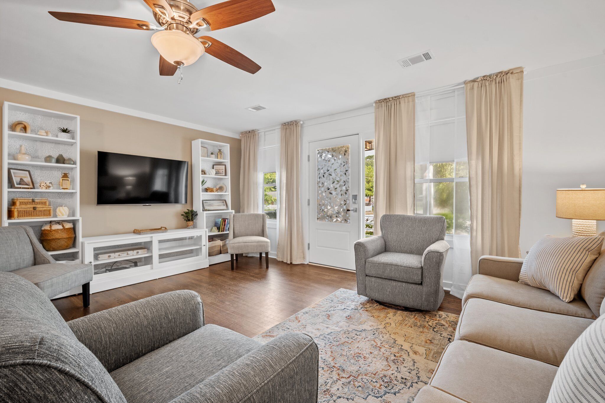 A living room with a ceiling fan, a television, and a bookshelf.