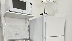 Eine kleine Küche mit Mikrowelle, Herd und Kühlschrank.