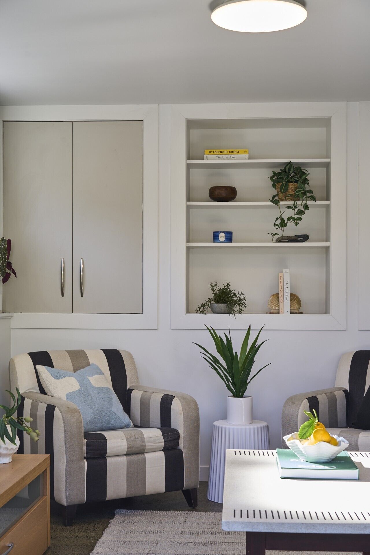 A living room with a sofa, a coffee table, a bookshelf, and a cabinet.