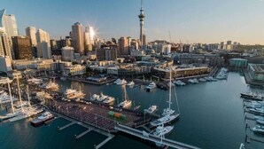 A cityscape with a prominent tower, marina with boats, and dense urban buildings. - Cosy Studio in the Award-Winning Union & Co (Auckland)