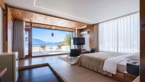 A modern hotel room with a large bed, a desk, and a view of the sea. - Dali Sky & Erhai Sea View Holiday Inn (Dali)
