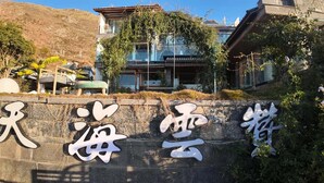A stone wall with large white characters, a building with traditional architecture, and a mountainous backdrop. - Dali Sky & Erhai Sea View Holiday Inn (Dali)