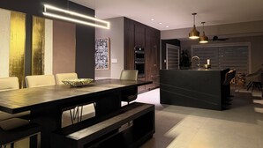 A modern kitchen with dark cabinetry, a central island, and pendant lighting. - Casa Solea Miami • Pool Home w/ Workspaces + Master Office & Daybed (Miami)