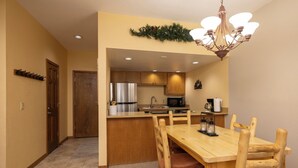 A compact kitchen with wooden cabinets, a stainless steel refrigerator, and a microwave. - Charming 1-bedroom condo at Cascade Village with stunning mountain views - 2 Miles from Purgatory (Durango)