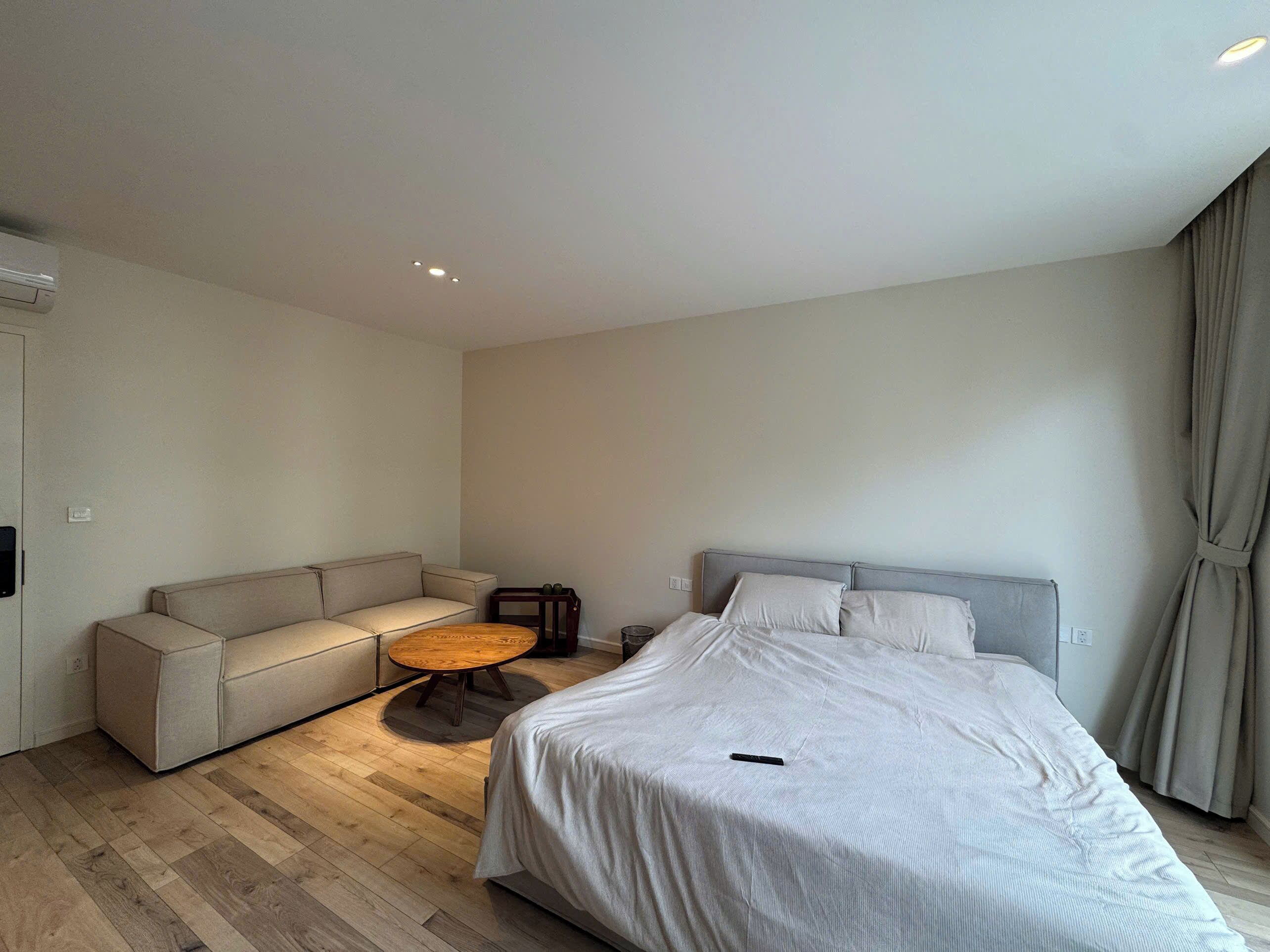 Une chambre à coucher moderne avec un lit, un canapé et une petite table ronde.