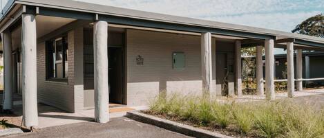 A building with a covered entrance, columns, and a sign indicating 'Boyd Suite'.