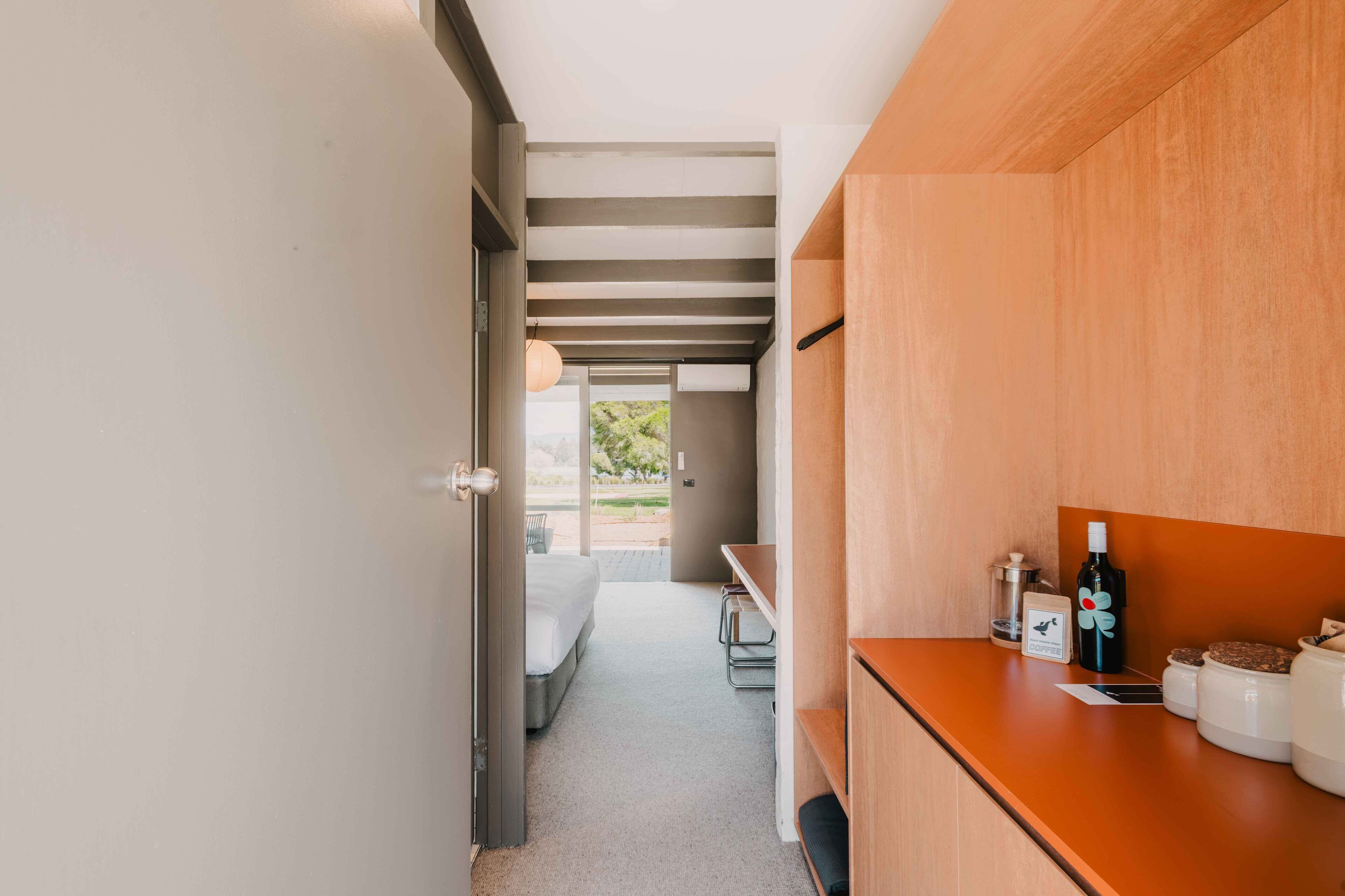 Een moderne hotelkamer met een bed, een houten bureau en uitzicht op de omgeving.