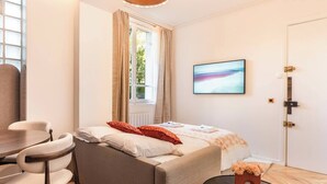 Een moderne slaapkamer met een bed, bureau en stoel.