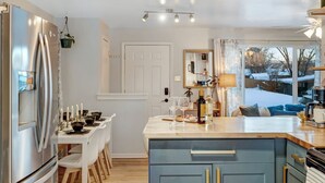 Een moderne keuken met een centraal eiland, roestvrijstalen apparatuur en uitzicht op de omgeving.
