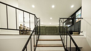 A staircase with black railings, wooden steps, and a green cushioned landing. - Remodeled Lakefront Retreat with Hot Tub (Lyon County)
