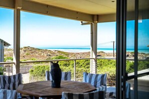 Ein überdachter Außenbereich mit Blick auf das Meer und die felsige Landschaft.