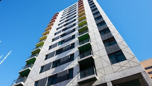 Ein Hochhaus mit einer geometrischen Fassade und mehreren Balkonen.