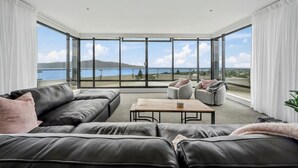 Una sala de estar moderna con un amplio ventanal, un sofá de cuero y una mesa de centro.