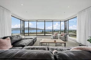 A modern living room with a large window, leather sofa, and a coffee table.
