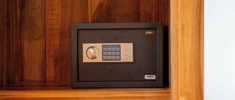 A safe with a keypad and a barcode on the bottom right, placed in a wooden cabinet.