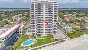A high-rise hotel with multiple balconies, a swimming pool, and a beach view. - Seas The Day- Oceanfront Daytona Beach Getaway – Huge Balcony, Steps to the Sand (Daytona Beach)