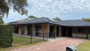 A two-story house with a tiled roof, a fenced yard, and a mailbox. -  Coastal Palms  Relaxing pet friendly accommodation with pool (Yamba)