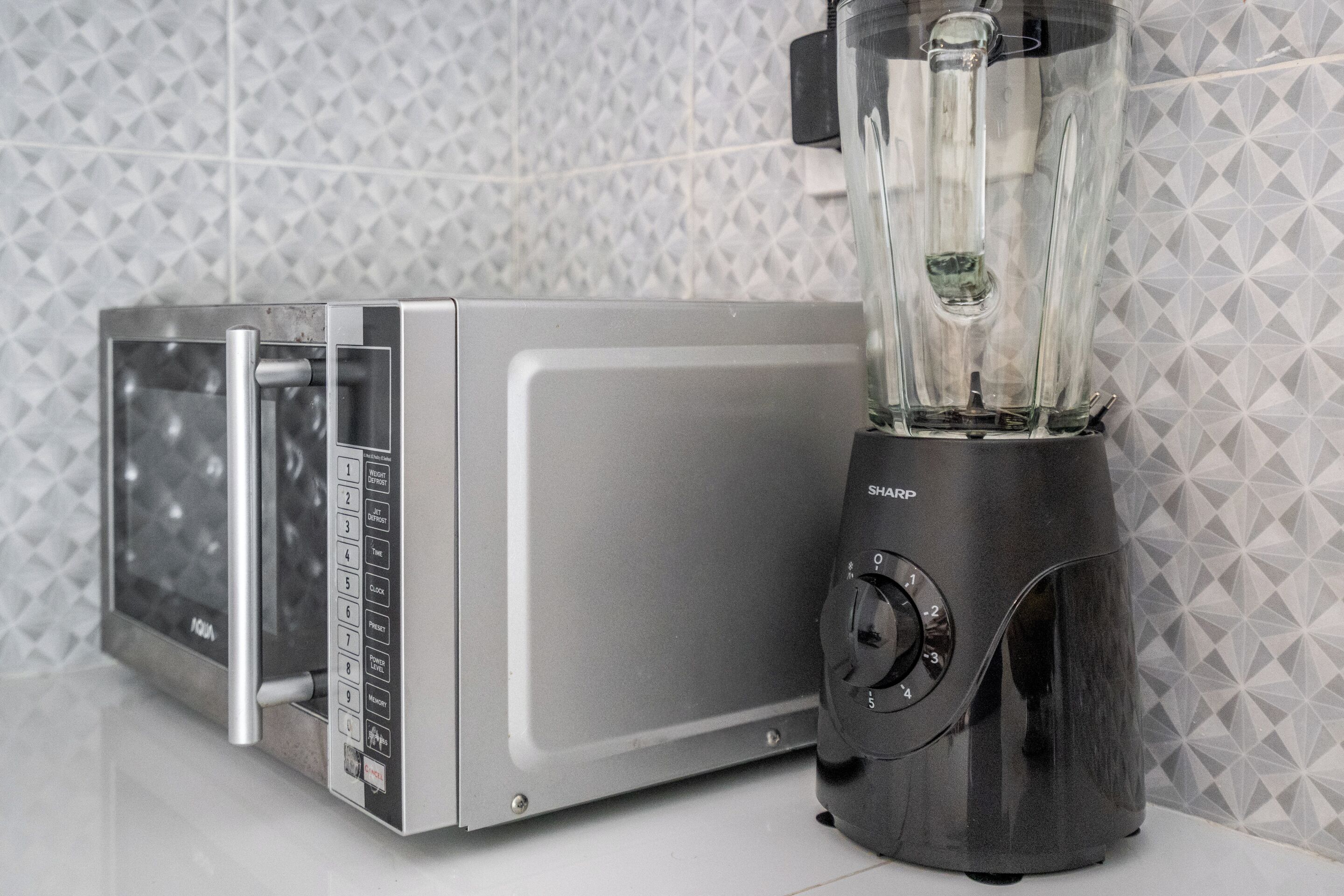 Et køkken med mikrobølgeovn og blender.