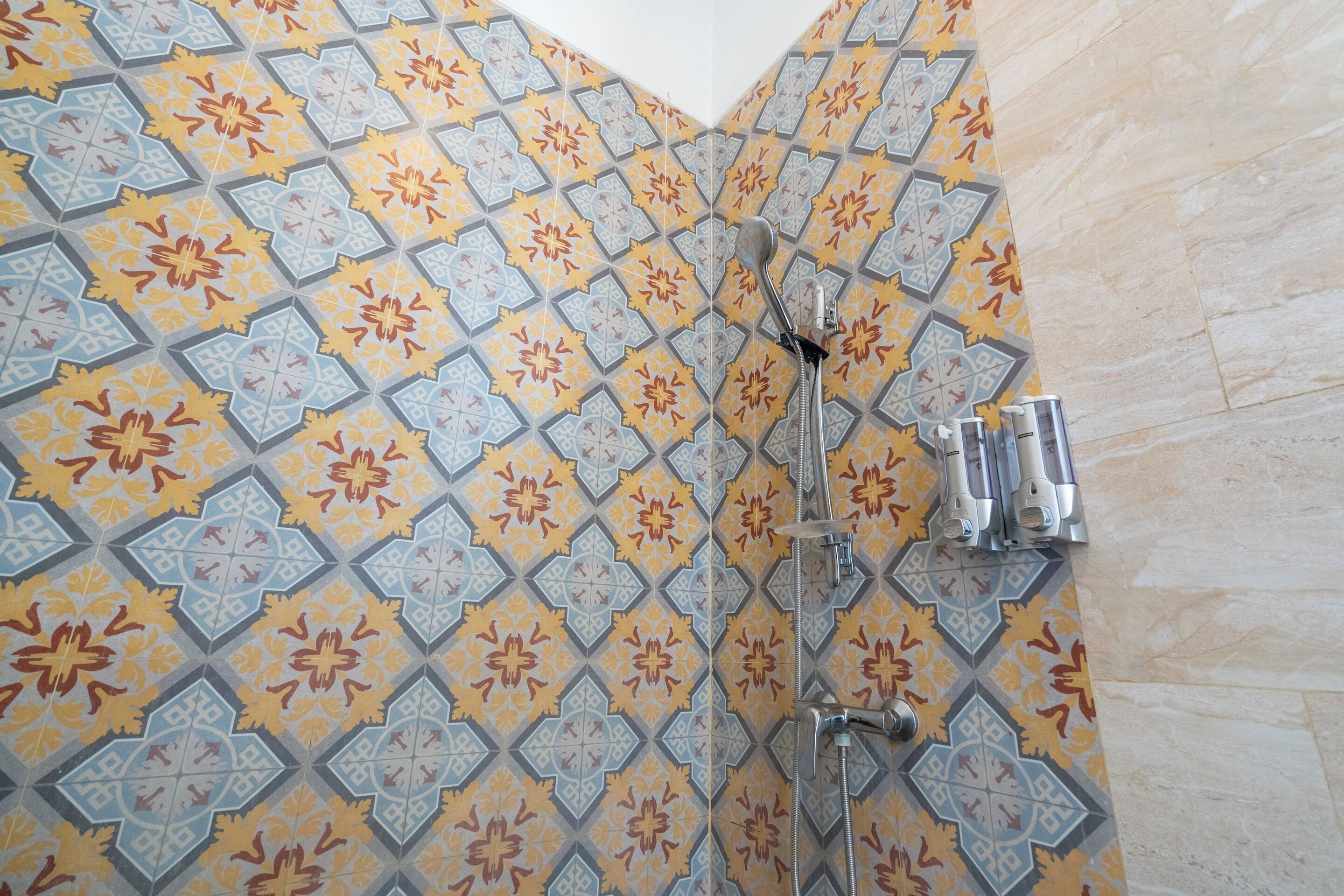 A shower area with a geometric patterned tile design.