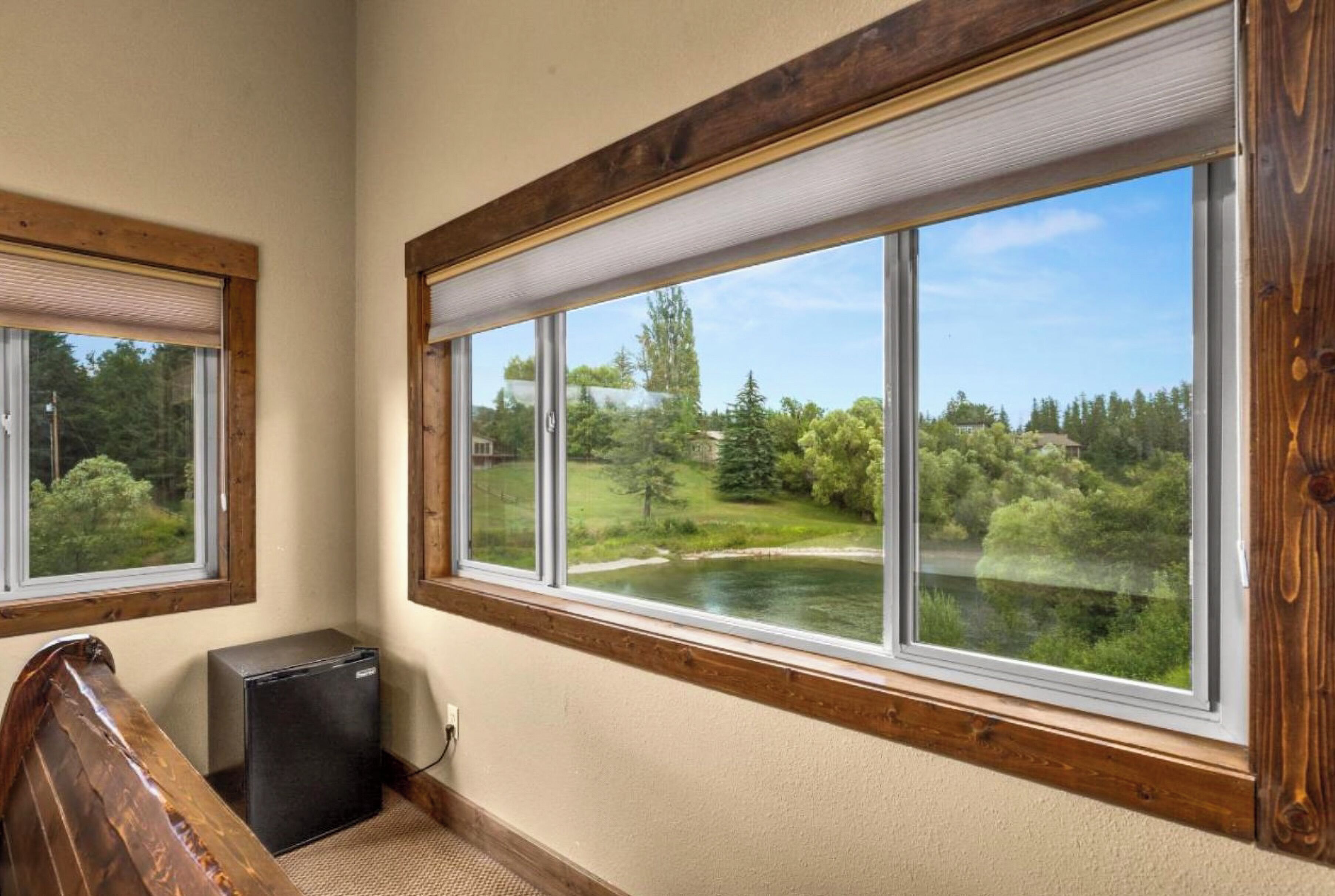 A room with a large window, a small desk, and a power outlet.