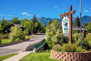 A Duck Inn sign, a wooden bridge, and a mountainous backdrop.