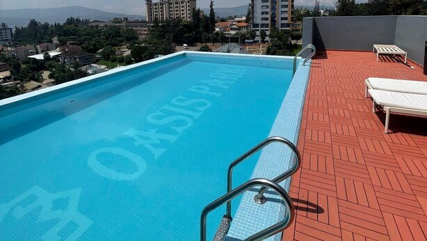 A rooftop pool with a clear view of the cityscape and mountains in the distance. - Trendy Oasis Park Studio in Kimihurura - Kigali (Kigali)