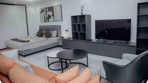 En moderne stue med sofa, sofabord, fjernsyn og bogreol.