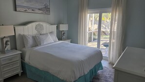Una camera da letto con un letto, comodini, un quadro e vista sull'esterno.