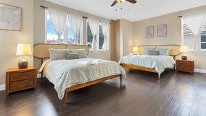 Una camera da letto con due letti, testiere in legno, comodini con lampade e una ventola a soffitto.