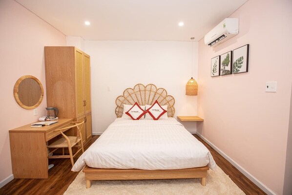 Un dormitorio con cama, armario de madera, escritorio y aire acondicionado de pared.