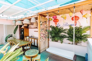 A cozy indoor dining area with a wooden table and chairs, a bench, and a wall with hanging lanterns. - La Bonté Boutique Home Vung Tau (Ho Chi Minh City)
